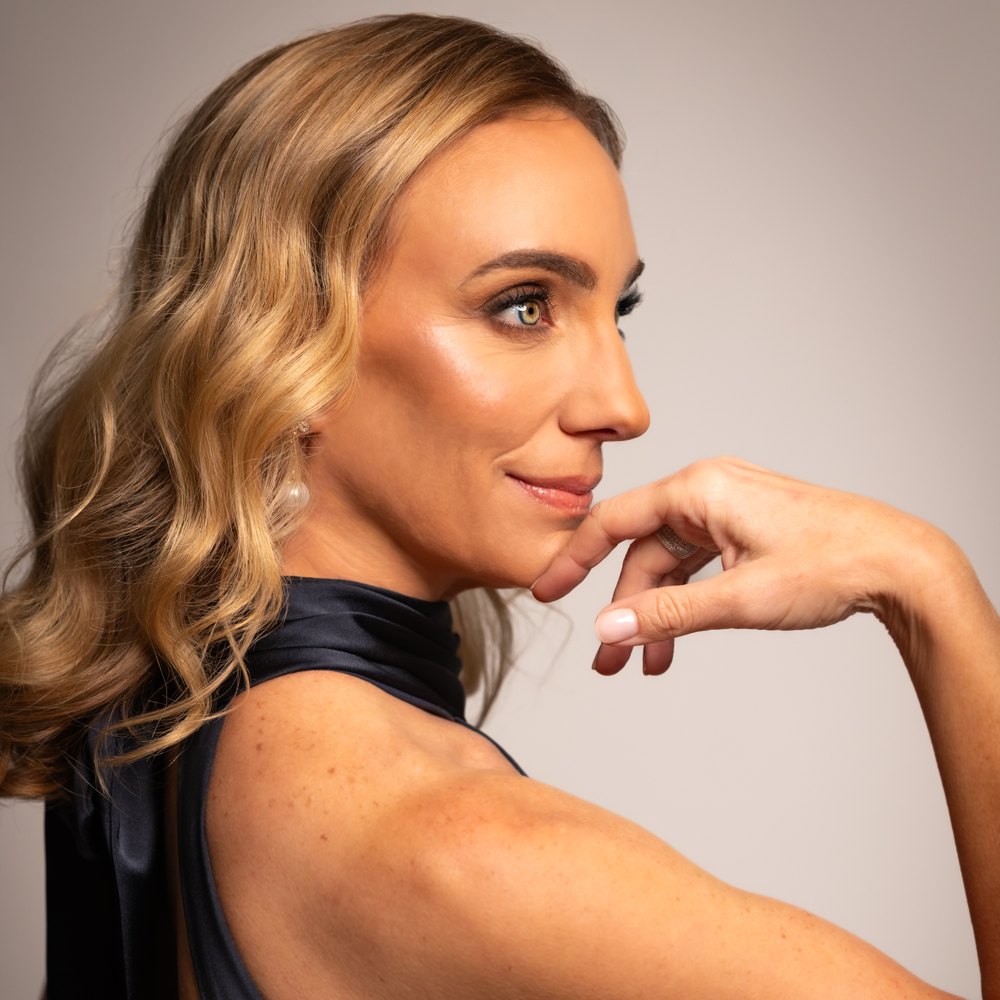 Laura Shoop in a navy halter gown, in profile with her hand at her chin